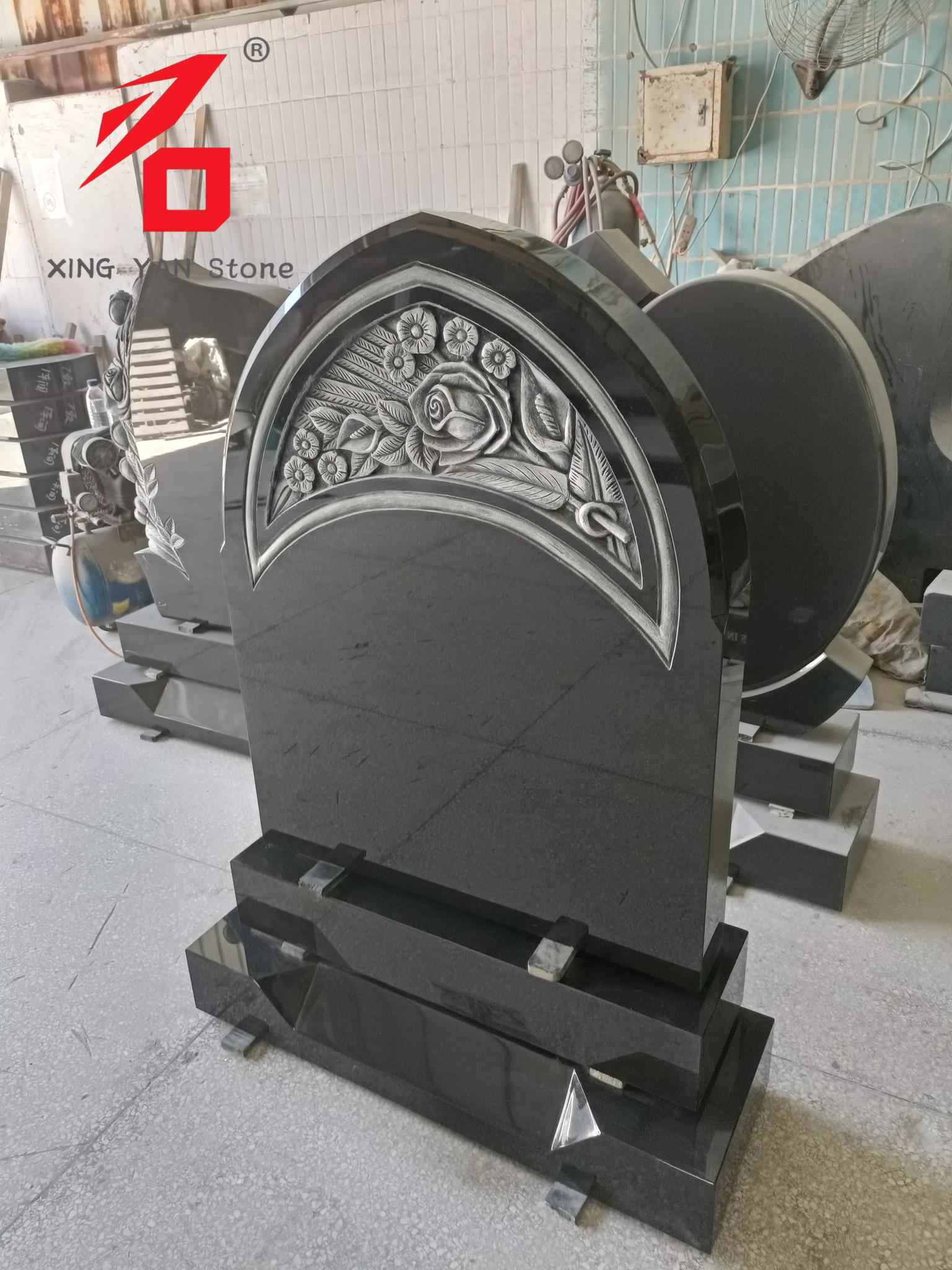 Roosiga nikerdatud hauakivi, mustast graniidist kaarjas hauakivi